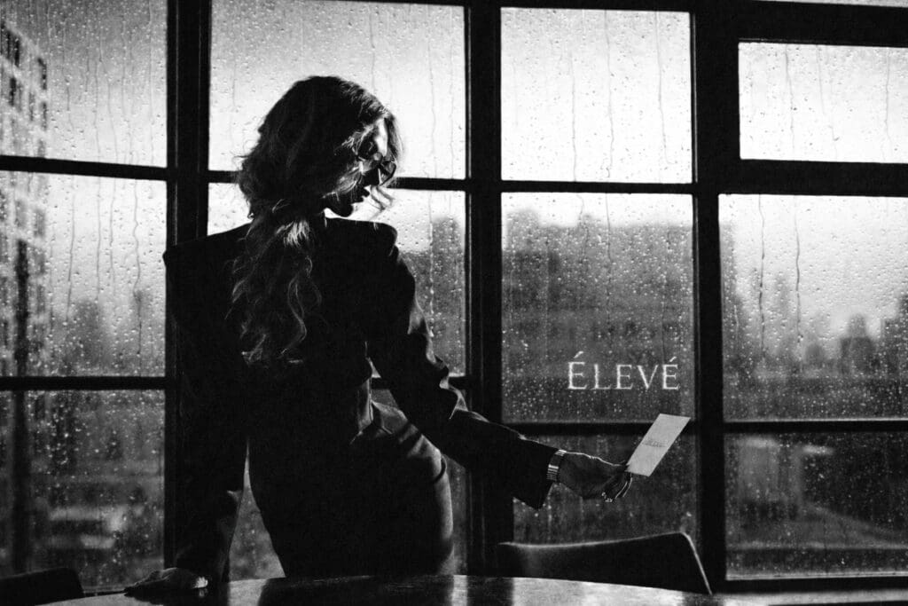 Wendy Jacobson, founder of Élevé, standing by a window in a reflective moment representing philosophy-driven leadership in modern aesthetics